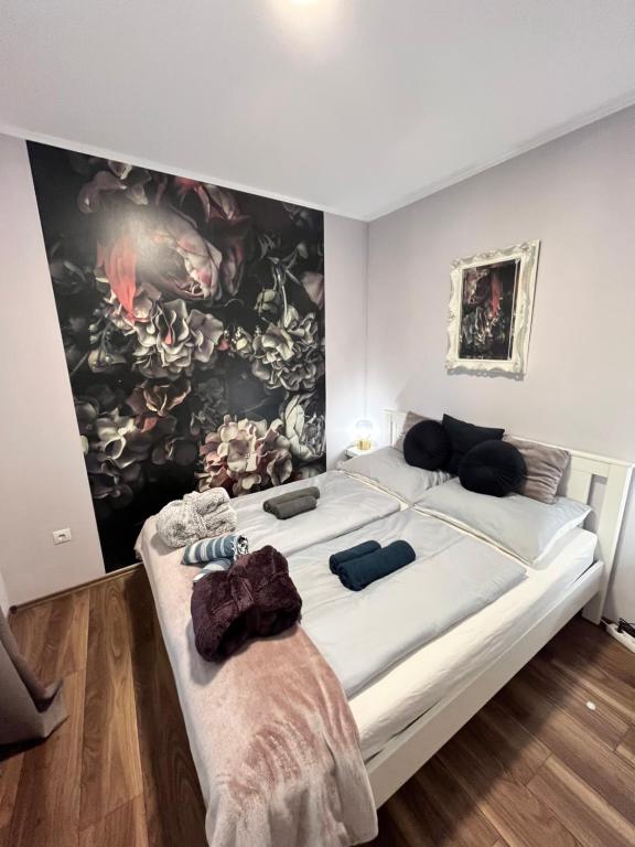 a bedroom with a large bed with a large painting on the wall at Városi Menedék in Veszprém