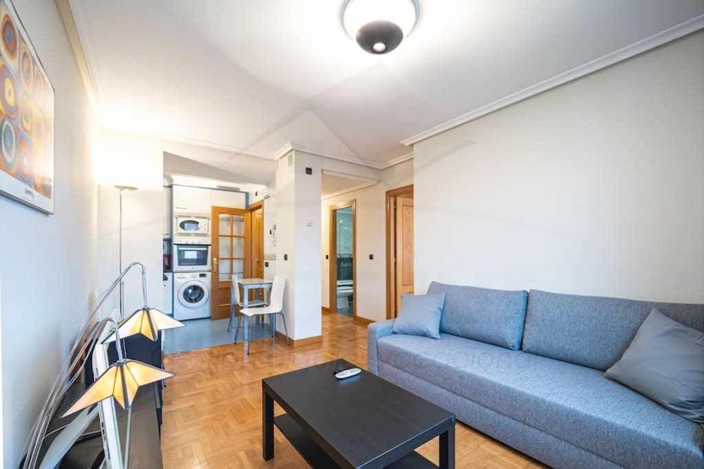 sala de estar con sofá azul y mesa en Santo domingo Apartamento, en Oviedo