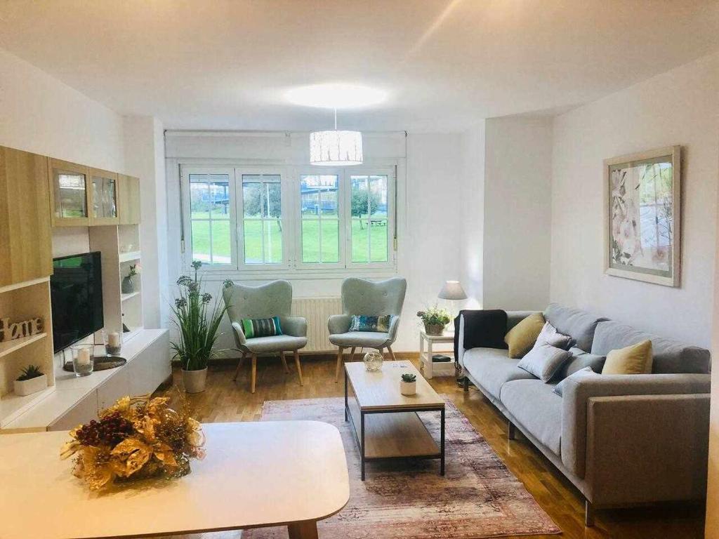 ein Wohnzimmer mit einem Sofa und einem Tisch in der Unterkunft Avenida Apartamento in Oviedo