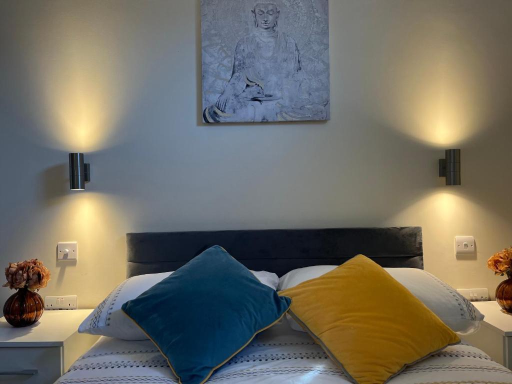ein Bett mit blauen und gelben Kissen in einem Schlafzimmer in der Unterkunft Pods of Kings Cross -1 in London