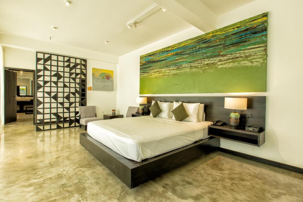 um quarto com uma cama e uma grande pintura na parede em Splendour Residence em Balapitiya