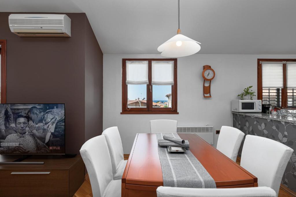 波雷奇的住宿－Biba Lux，一间带木桌和白色椅子的用餐室