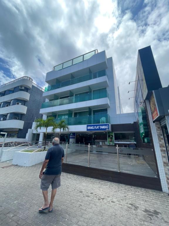a man standing in front of a building at ISRAEL FLAT DUPLEX C/ PISCINA in João Pessoa