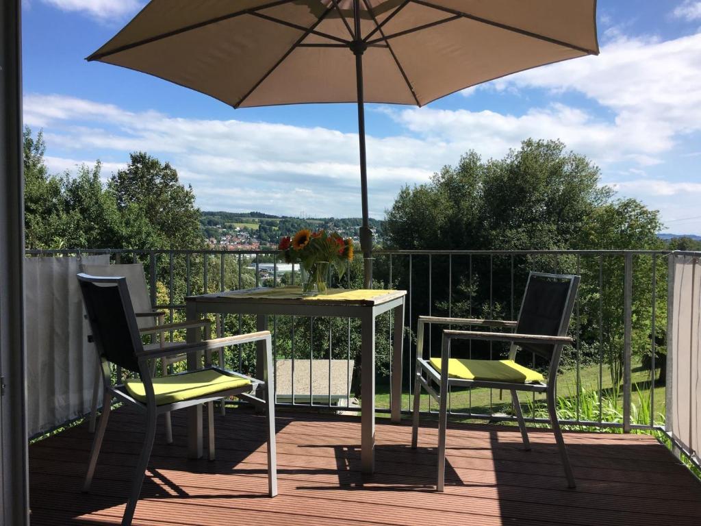 a table and two chairs and an umbrella on a deck at A Home away from Home in Ravensburg