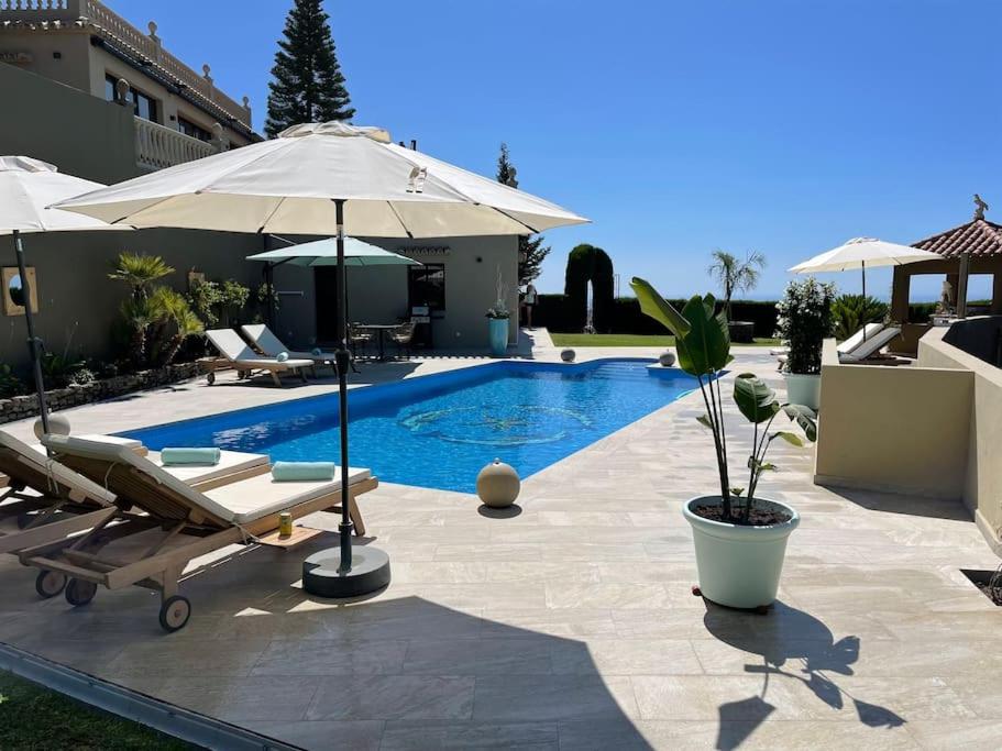 basen z 2 leżakami i parasolem w obiekcie El Sentimiento Don Javier Apartment w mieście Torrox