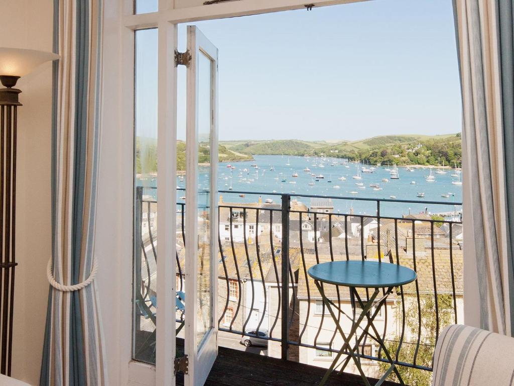 a room with a balcony with a view of the water at Estuary View in Salcombe