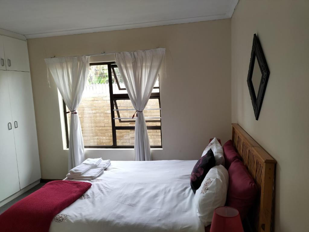 Un dormitorio con una cama grande con ventana. en 15 on 11th Summerstrand, en Summerstrand