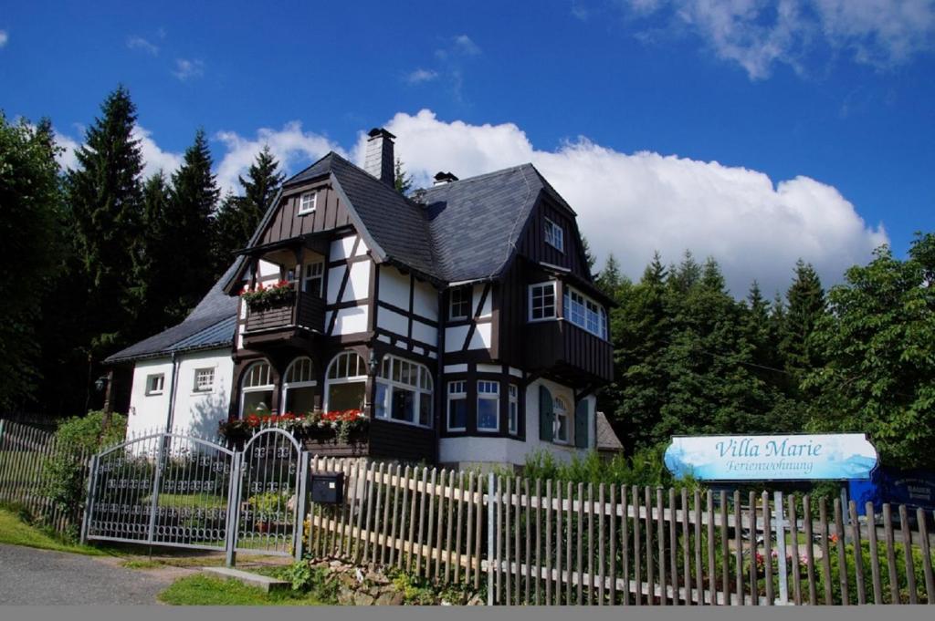 een zwart-wit huis met een hek bij Villa Marie Ferienwohnungen in Kurort Altenberg