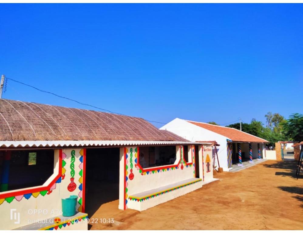 Rann Chandni Resort, Kutch, Bhuj في Bherandiāla: مجموعة من المنازل مع الطلاء الملون عليها