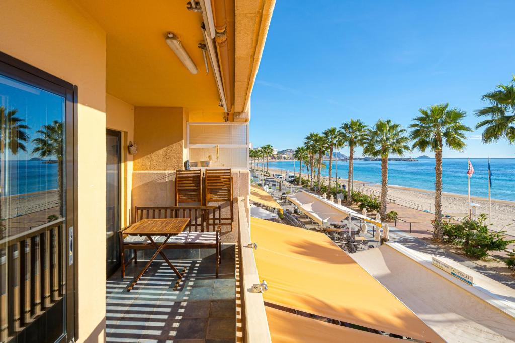 a balcony with a table and a view of the beach at Apto Villajoyosa 1ª línea in Villajoyosa