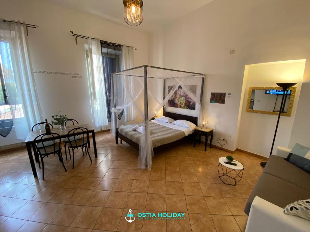 リド・ディ・オスティアにあるCasa Vacanze Naxosのベッドルーム(天蓋付きベッド1台、テーブル、椅子付)