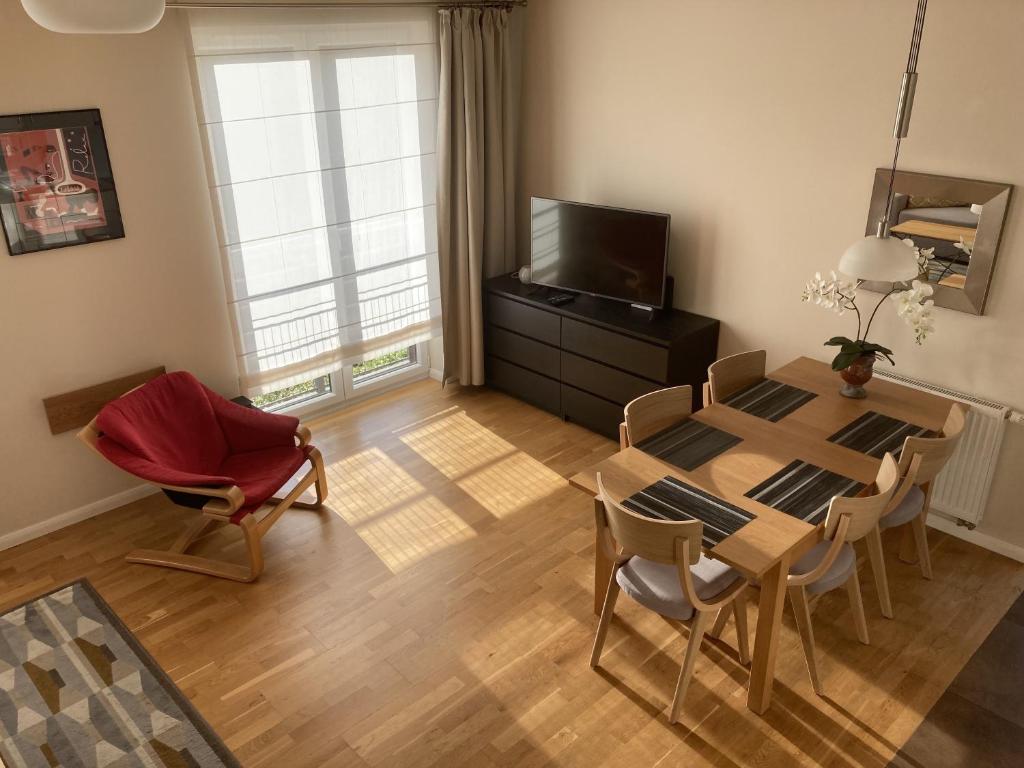 sala de estar con mesa, sillas y TV en Apartament Beige, en Polanica-Zdrój