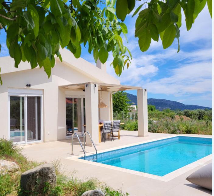 een villa met een zwembad en een huis bij Casa O' - Moderne Villa mit großer Terrasse und privatem Swimmingpool in Skala Potamias