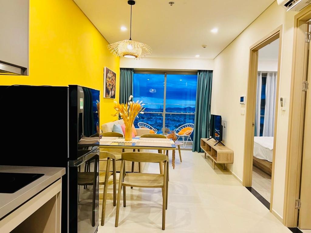 a kitchen with yellow walls and a table with chairs at Mochi House - Căn hộ The Sóng in Vung Tau