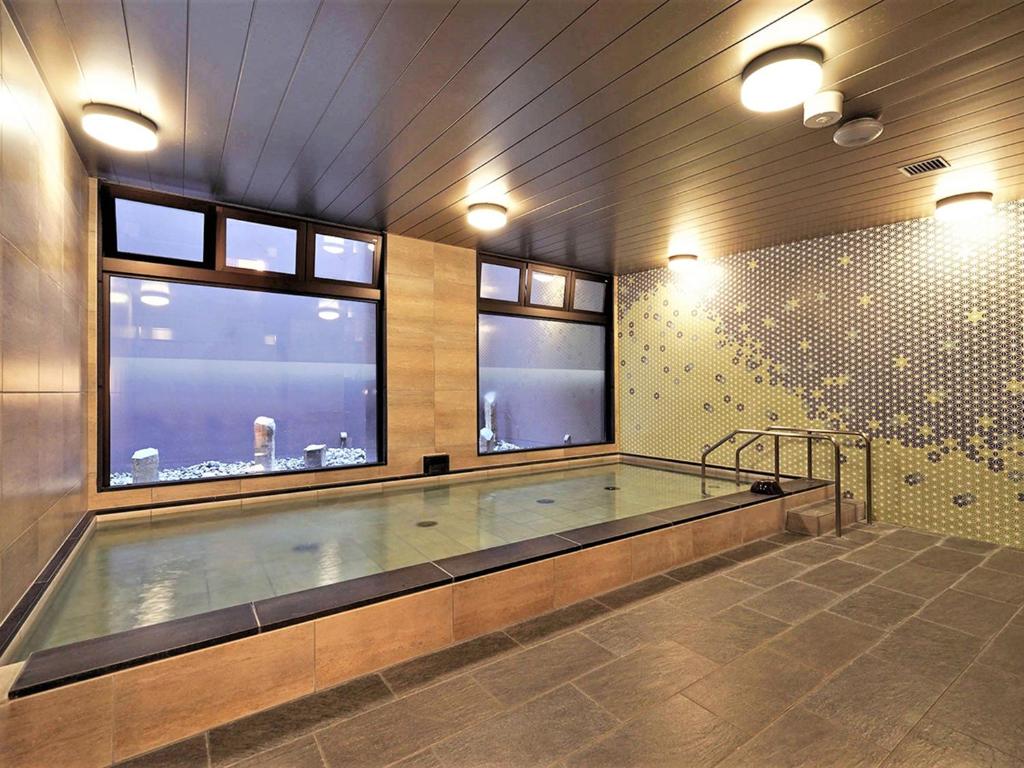 a swimming pool in a room with two windows at CHISUN PREMIUM Kyoto Kujo in Kyoto