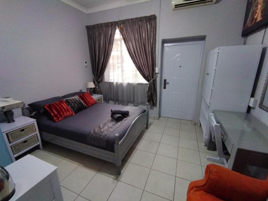 a bedroom with a bed and a window at 21on2nd Avenue in Tzaneen