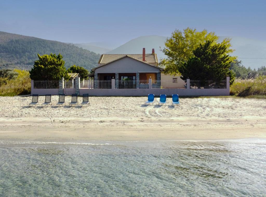 a house on the beach with the water at Unique Thasos Beach Villa in Prinos