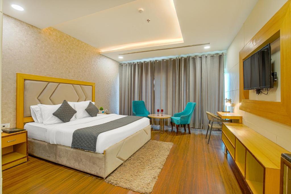 um quarto de hotel com uma cama e uma televisão de ecrã plano em The Stories Hotel em Ludhiana