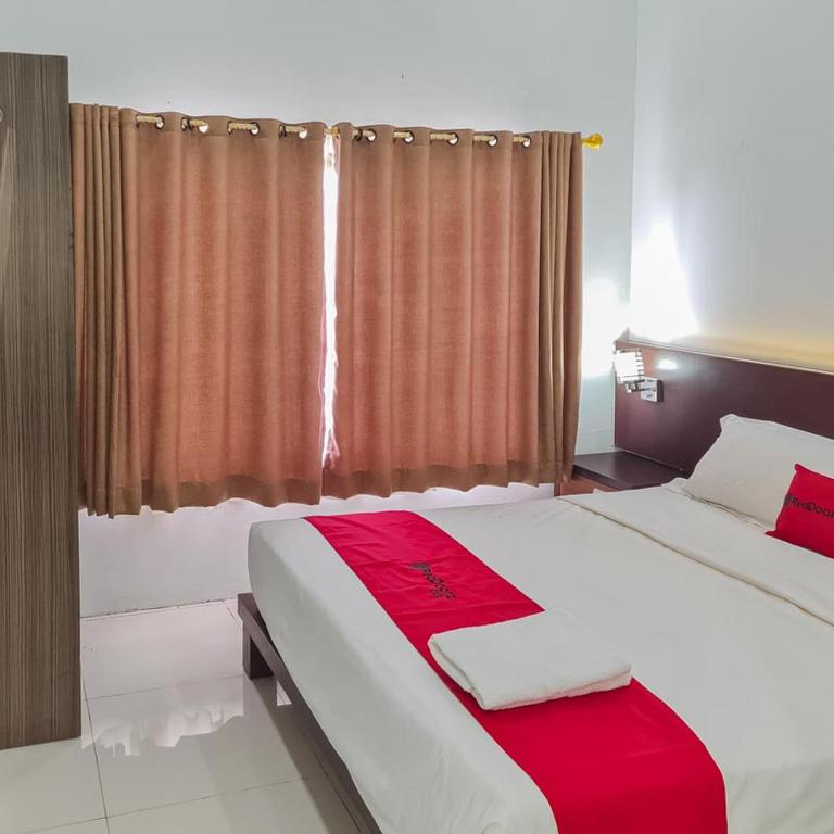 Gulta vai gultas numurā naktsmītnē RedDoorz Plus at Hotel Royal Palangka Raya