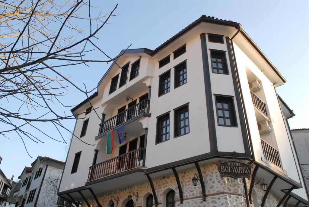 a tall white building with balconies on it at Hotel Bolyarka in Melnik