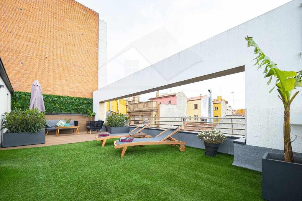 d'une terrasse avec une pelouse et un hamac. dans l'établissement Palomar de Corrida Atico con terraza, à Gijón