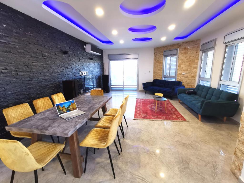 - un salon avec une table, des chaises et un canapé dans l'établissement Villa Tzukim Mitzpe Ramon, à Mitzpe Ramon