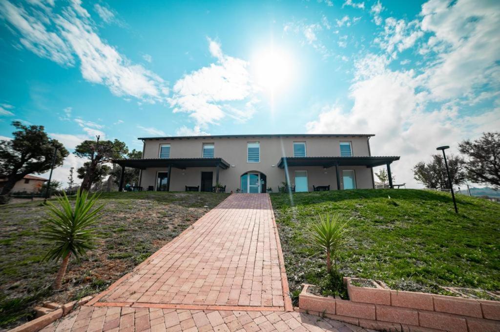 a house with a brick walkway in front of it at Agriturismo Il Colle Dei Lecci in Ancona