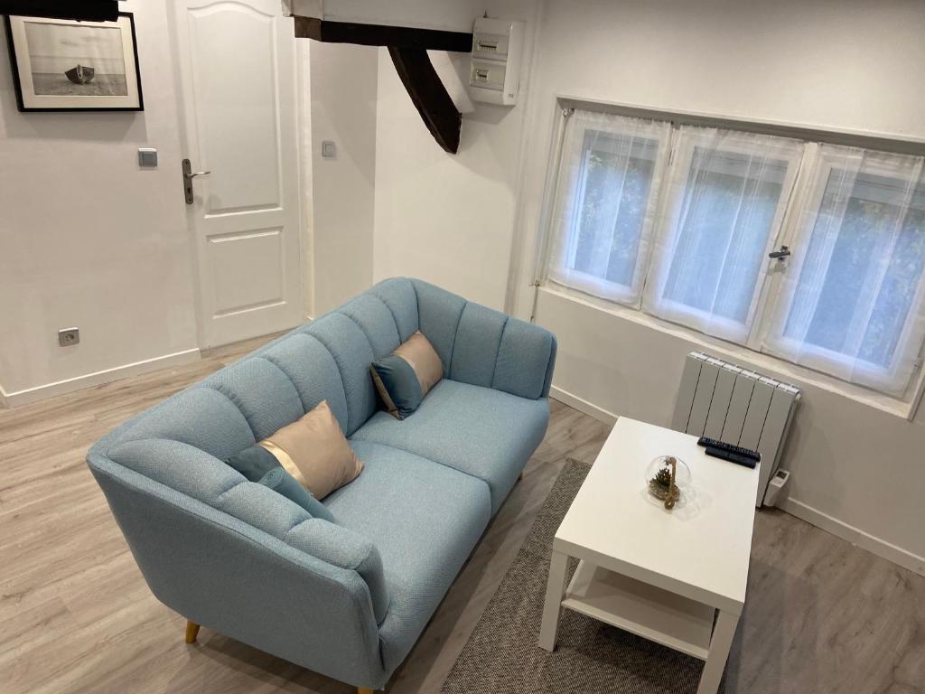 - un salon avec un canapé bleu et une table dans l'établissement Chantignolle, proche aéroport, à Tillé