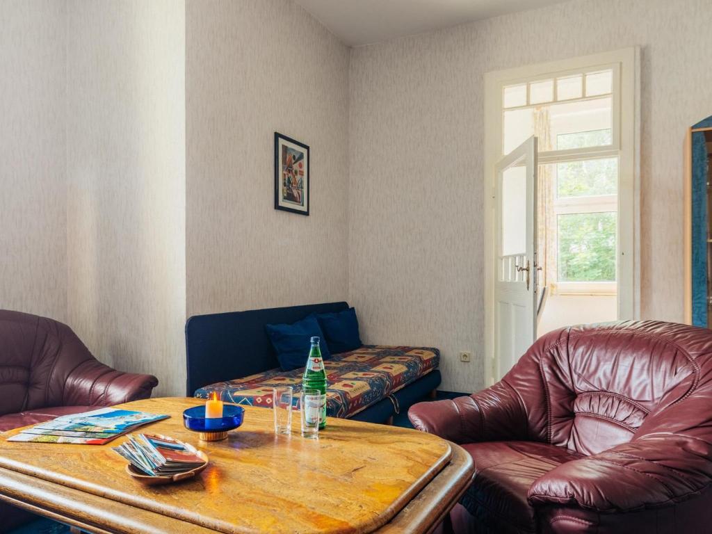 a living room with leather chairs and a table with a bottle at Ferienwohnung Rorik - Schierke in Schierke