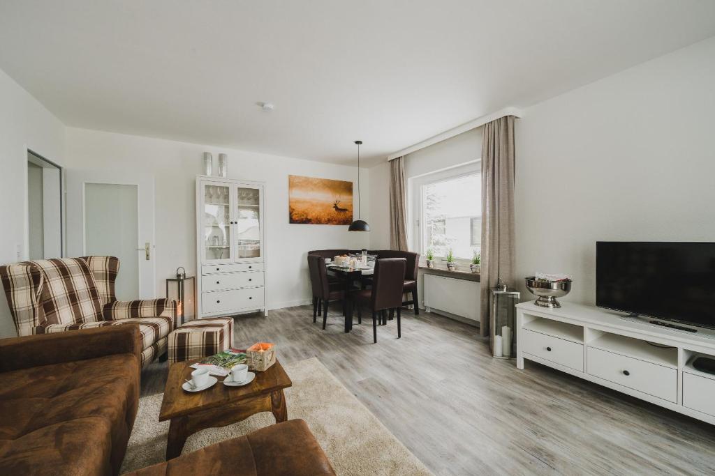 a living room with a couch and a dining room at Harzer Auszeit in Braunlage