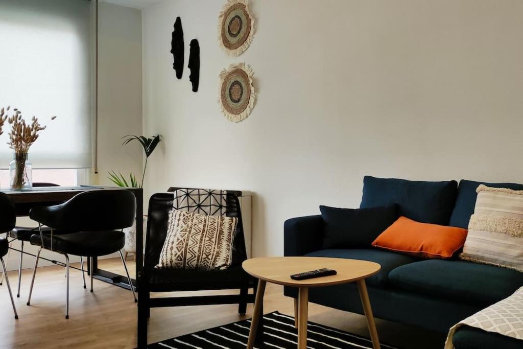 uma sala de estar com um sofá azul e uma mesa em Ultreia , piso turístico termal em Ourense