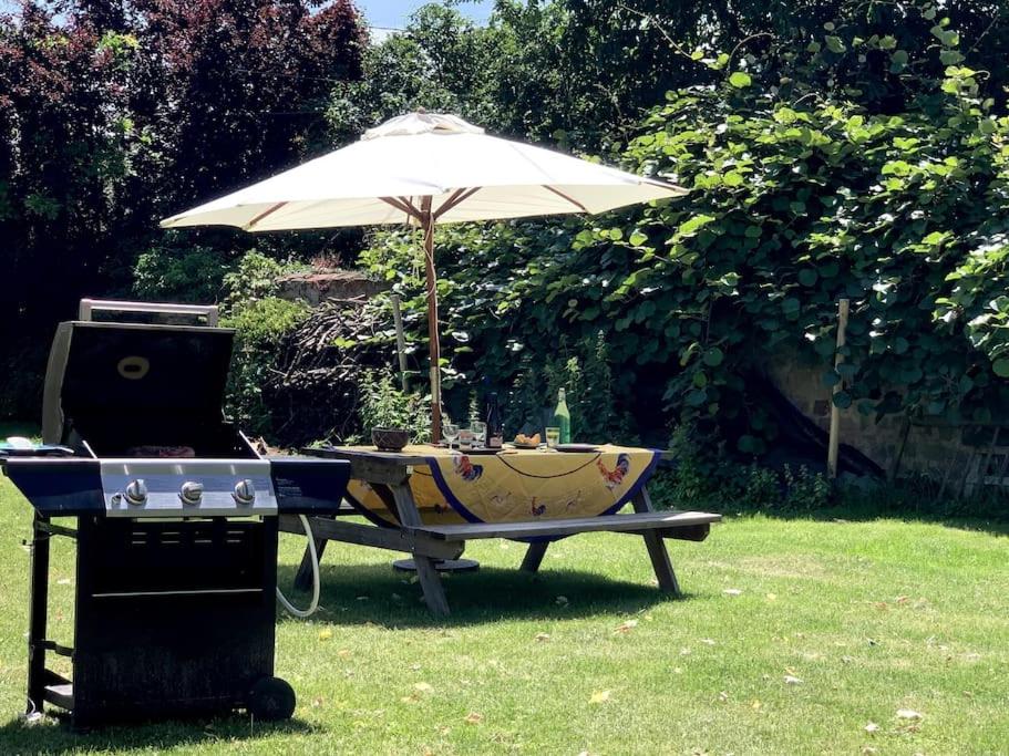 una mesa de picnic con sombrilla y parrilla en F3 avec Jardin, Calme, Fôret, Barbizon, en Chailly-en-Bière