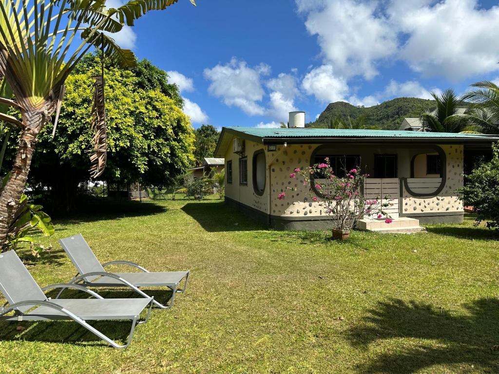 um par de cadeiras e uma casa no quintal em 88 Days Self Catering Holidays & Accomodation em Baie Lazare Mahé