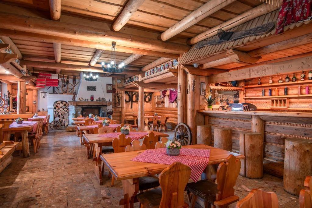 a restaurant with wooden tables and chairs and a bar at Turistické ubytovanie Sova in Ždiar