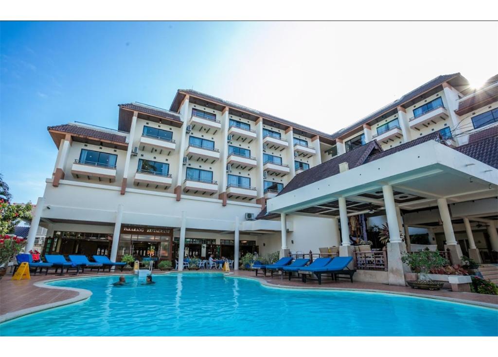 un hôtel avec une piscine en face d'un bâtiment dans l'établissement Phi Phi Hotel, sur les Îles Phi Phi