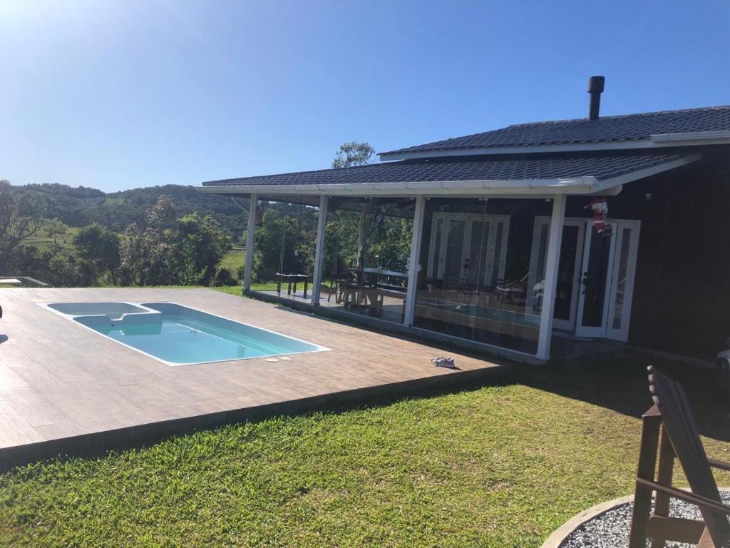 a house with a swimming pool in the yard at Cabana Guimarães in Rancho Queimado