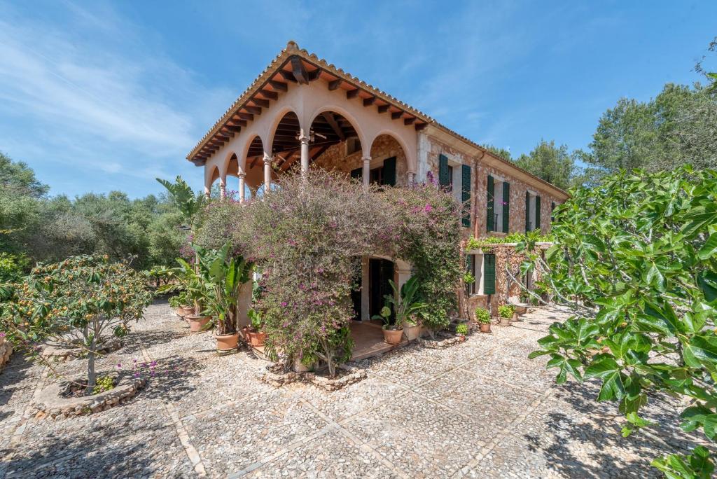 a building with a bunch of plants in front of it at Finca La Encina by Mallorca House Rent in Porreres