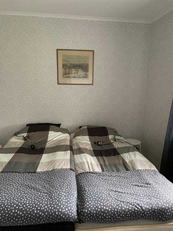 a bedroom with two beds and a picture on the wall at Lövåsen in Glava