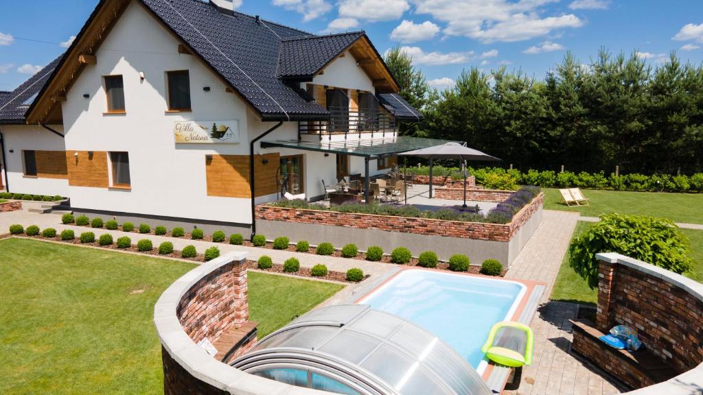a home with a swimming pool and a house at Villa Natura Zator Przeciszów in Zator