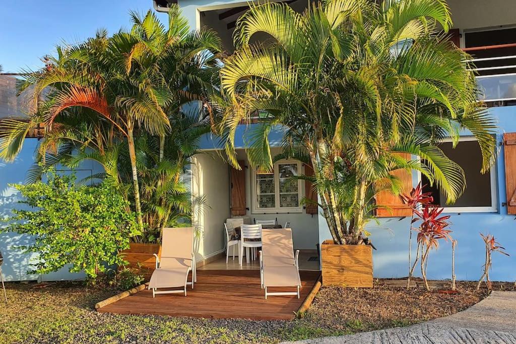 a house with palm trees and a table and chairs at 972D2 - Gwozey - Bas de villa Tamarin in Rivière-Salée