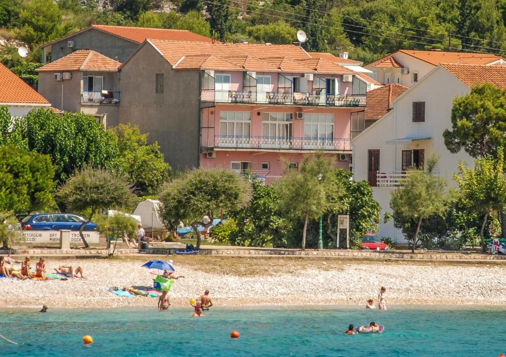 un grupo de personas jugando en el agua en una playa en Lulak Studio Apartments, en Orebić