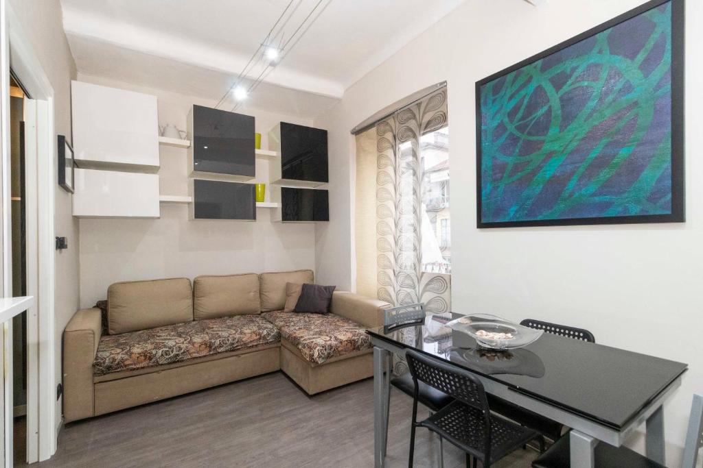uma sala de estar com um sofá e uma mesa em San Salvario Stylish Apartment em Turim
