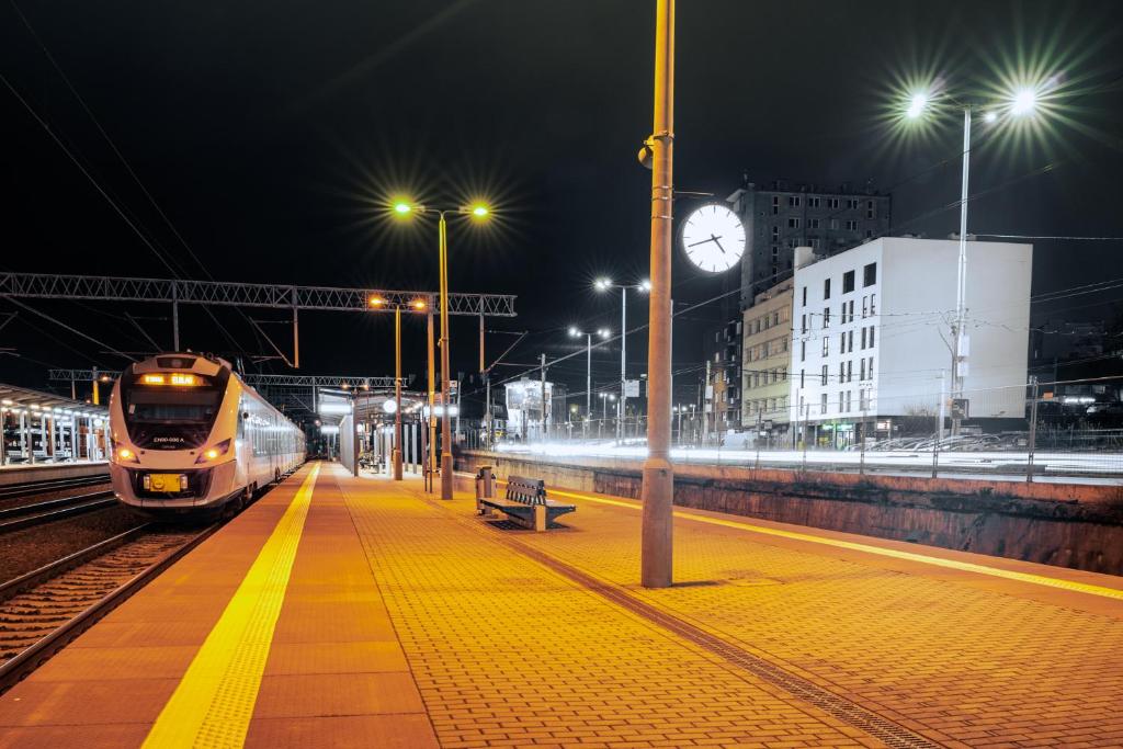 un tren está llegando a una estación de tren por la noche en Apartamenty Przystanek Morska, en Gdynia