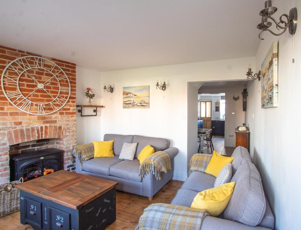 a living room with two couches and a fireplace at Stylish Town Centre House with Garden and Parking Opposite in Bury Saint Edmunds