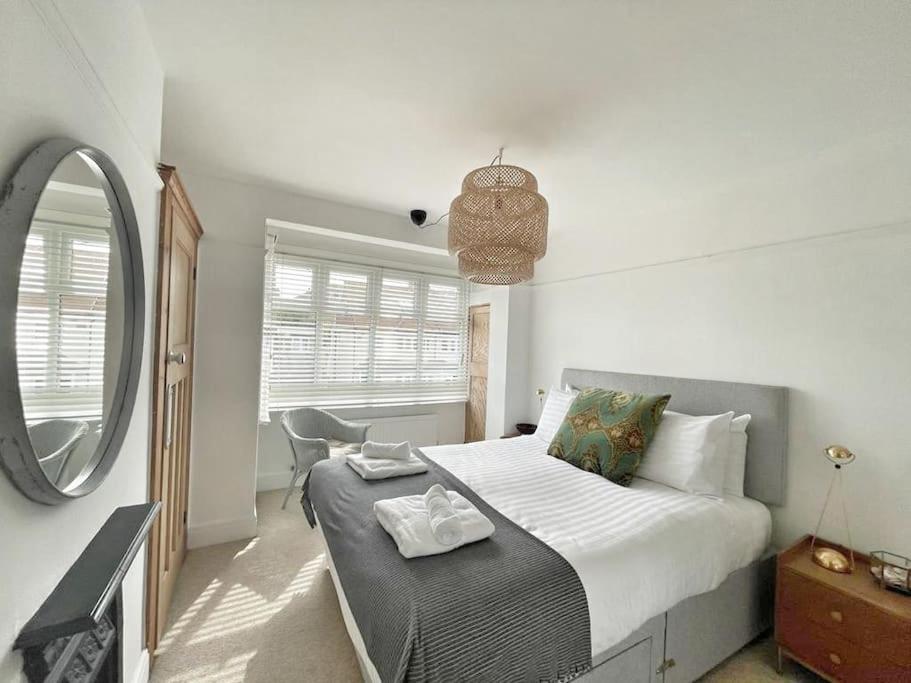 a bedroom with a large bed and a mirror at Home away from Home - Broadstairs beautiful family seaside house with garden and parking in Kent
