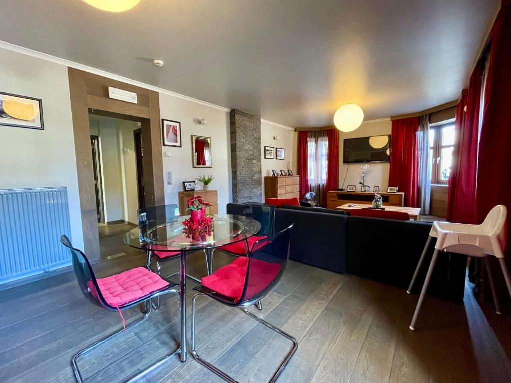 ein Wohnzimmer mit einem Glastisch und Stühlen in der Unterkunft City Apartments by Malmedreams in Malmedy