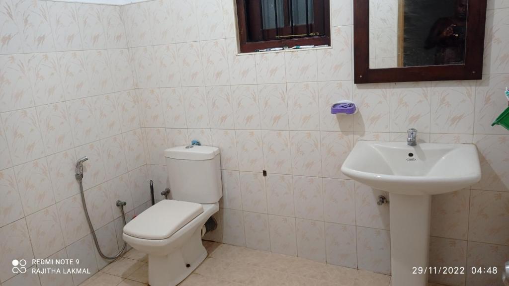 a bathroom with a toilet and a sink at Villa RnG in Dickwella