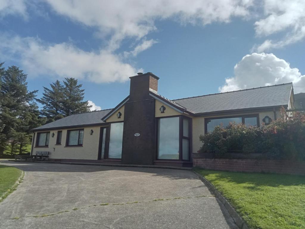 a house with a driveway in front of it at Impeccable 5-Bed Cottage in fahan buncrana in Buncrana