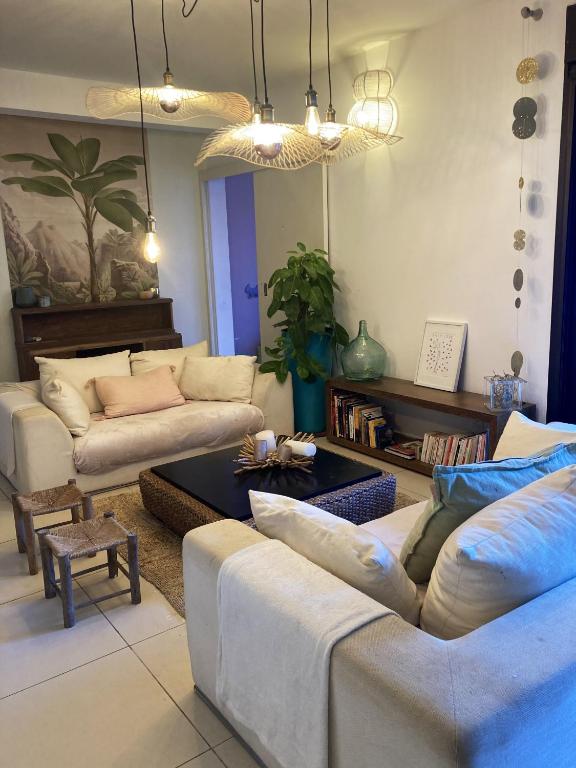 a living room with two couches and a table at Maison de 3 chambres avec jardin clos et wifi a Saint Denis in Saint-Denis