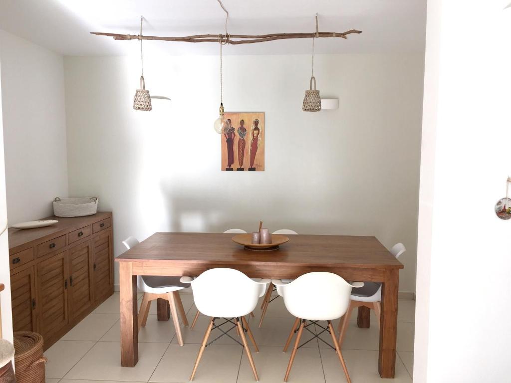 a dining room with a wooden table and two white chairs at Maison de 3 chambres avec jardin clos et wifi a Saint Denis in Saint-Denis